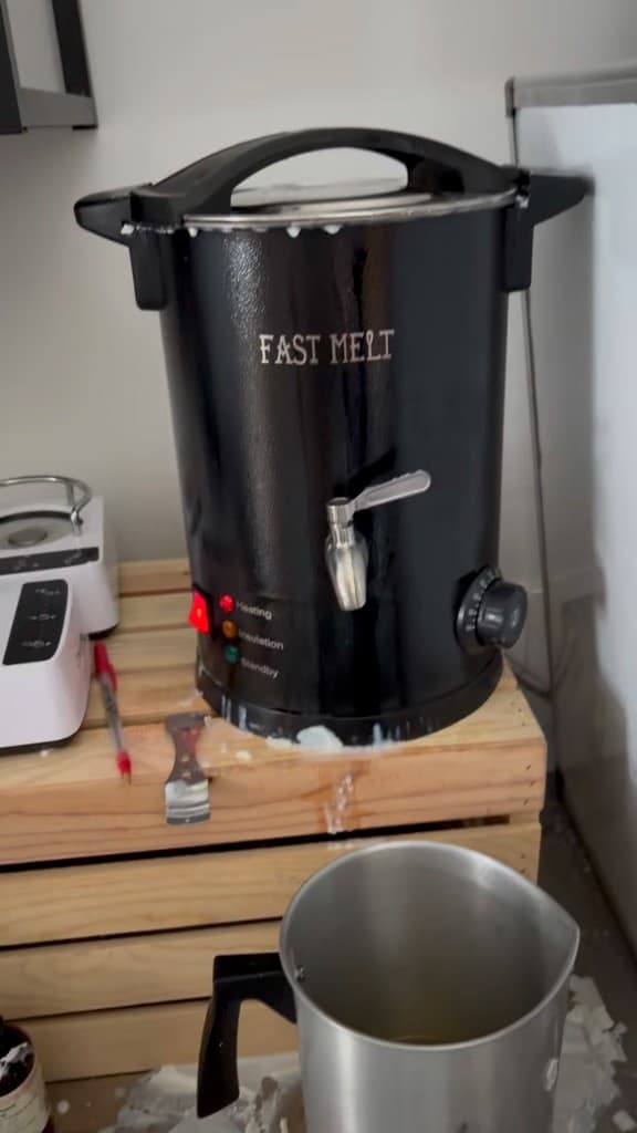 The Fast Melt wax pot on a crate, heating, with a pitcher under the spigot